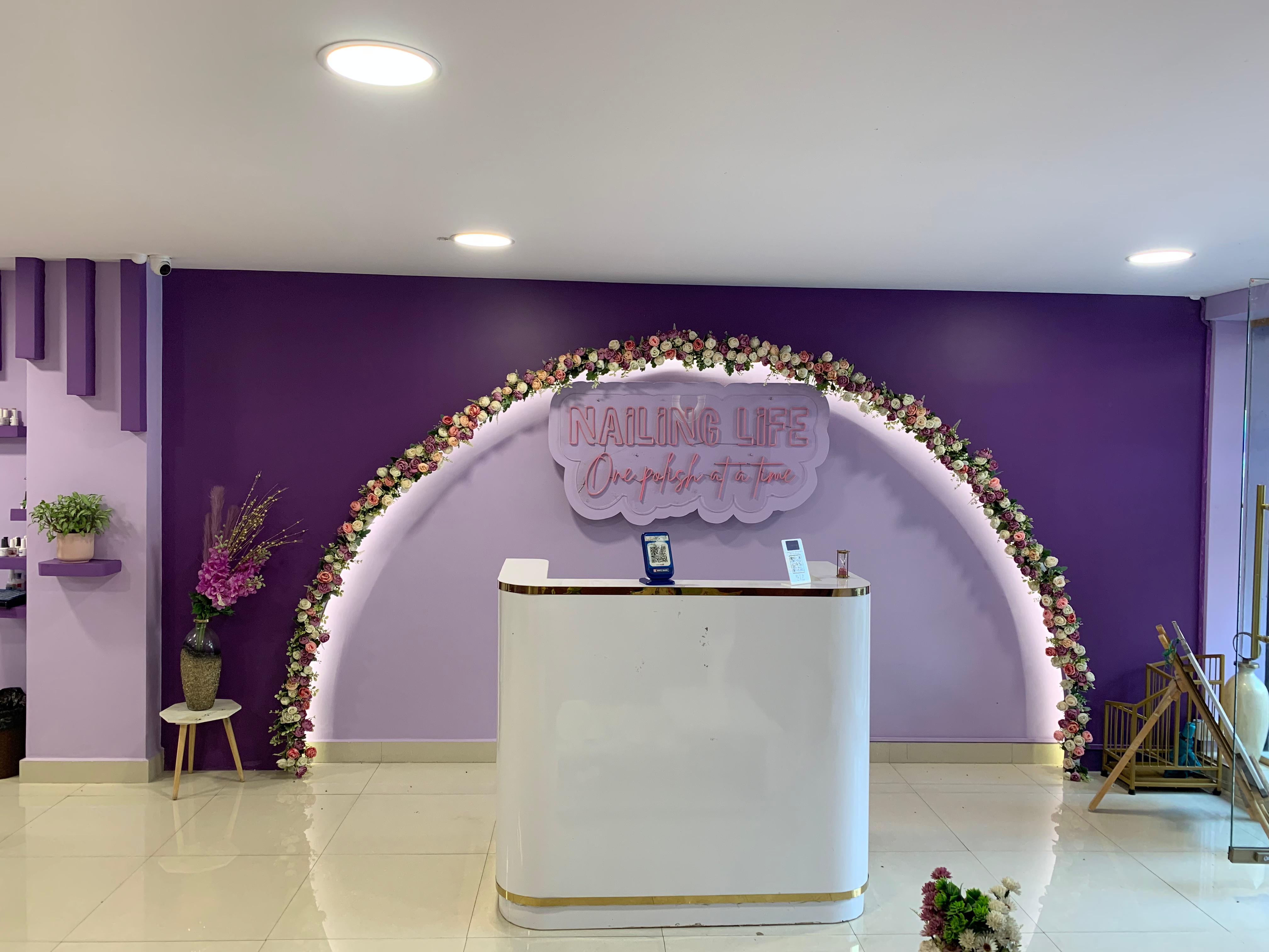 Nail Charm studio reception with branded neon signage